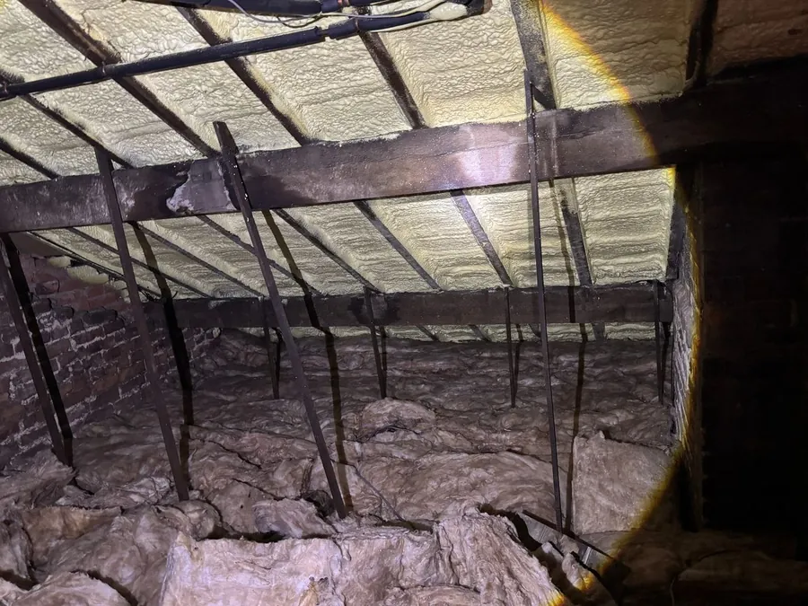 Independent spray foam inspection — closed-cell spray foam applied to the underside of the roof covering rafters and felt, with mineral-wool insulation at ceiling level